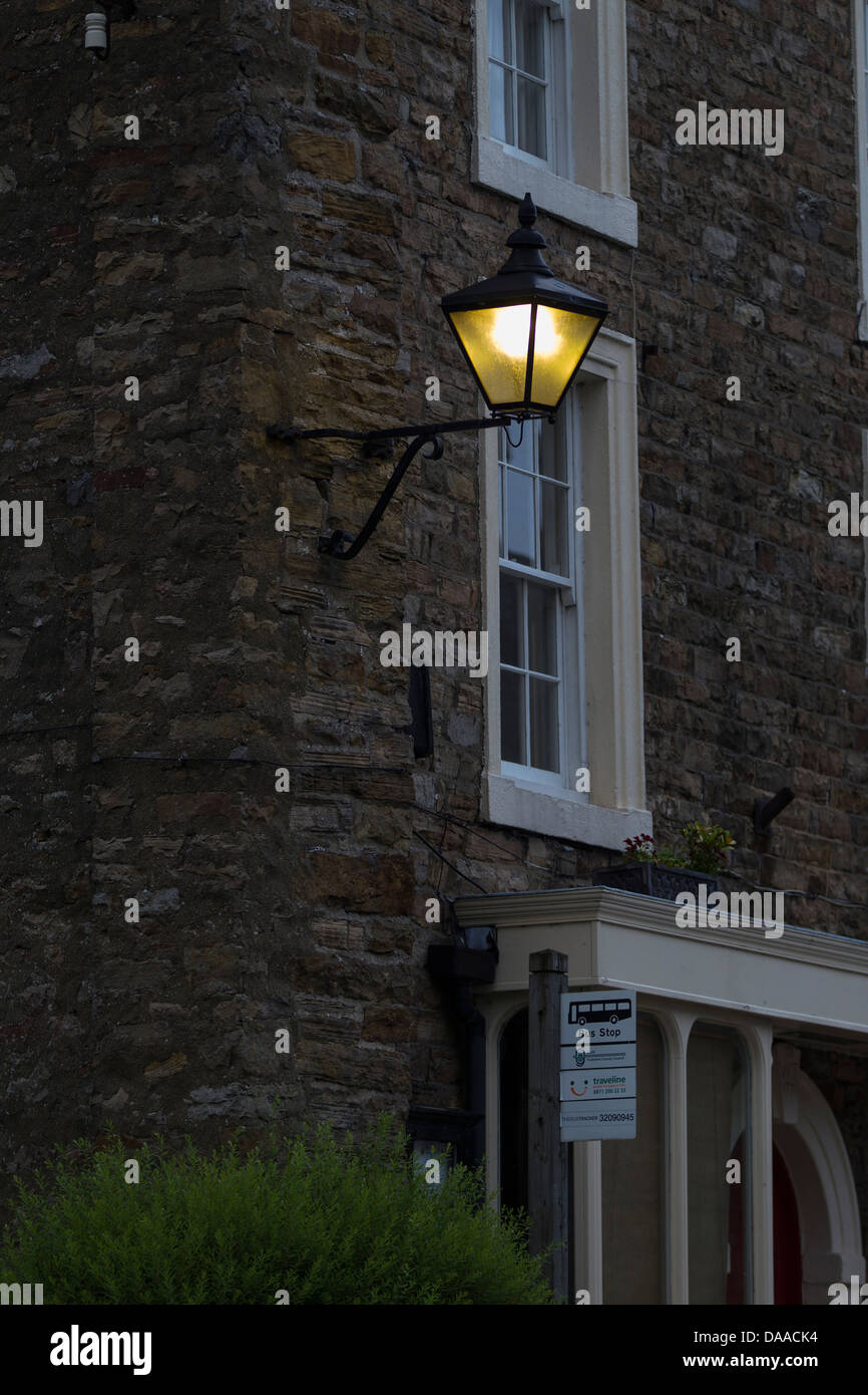 Old lamps lite up at dusk in Askrigg, North Yorkshire Stock Photo