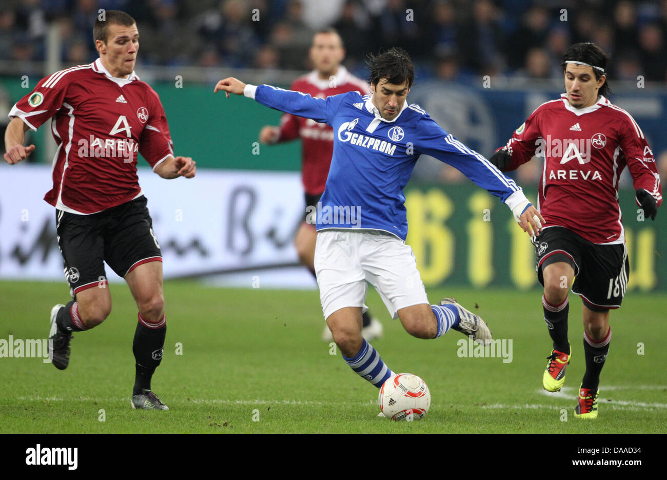 Soccer Quarter-Finale: FC Schalke 04 versus 1.FC: Nürnberg on 25 January 2011 at the Veltins-Arena in Gelsenkirchen, Germany. Schalke player Raul Gonzales Blanco (middle) is fighting for the ball with Christian Eigler(L) and Almog Cohen (R)Photo: Friso Gentsch    (ATTENTION: The DFB prohibits the utilisation and publication of sequential pictures on the  internet and other online m Stock Photo
