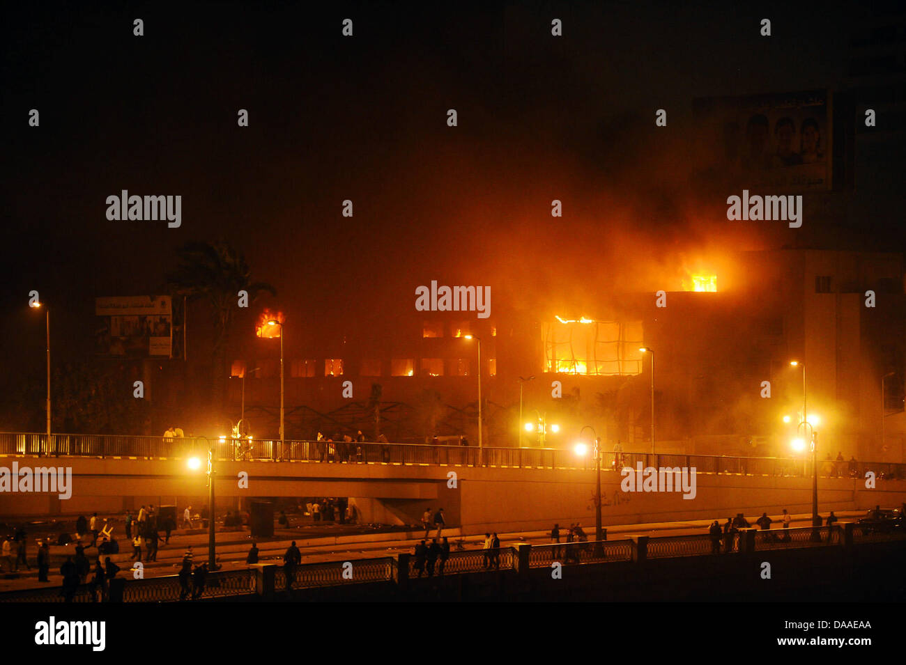 Ein Gebäüde der Regierungspartei Mubaraks - Nationaldemokratische Partei (NDP) - brennt in der Nacht zum Samstag (29.01.2011) in Kairo lichterloh. Die Plünderungen und Ausschreitungen in der ägyptischen Hauptstadt Kairo sind auch am Samstagmorgen weitergegangen. Dies berichteten Augenzeugen. In zwei Kairoer Vierteln seien aus gestürmten Polizeiwachen Häftlinge befreit worden. Auch  Stock Photo
