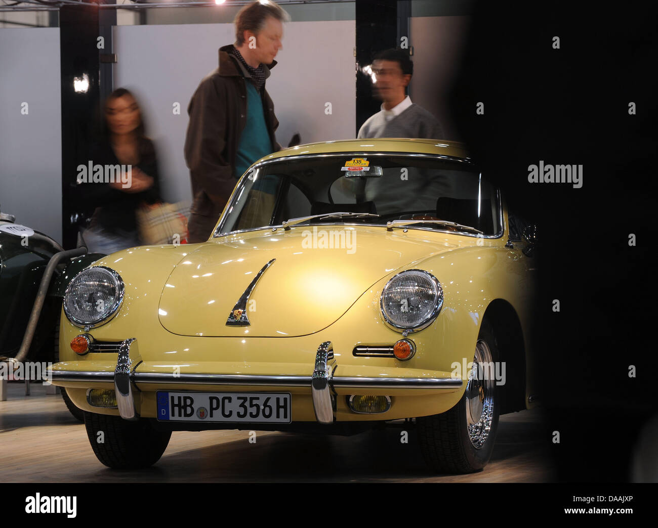 Visitors swarm around this yellow Porsche 356 from the 1960's at this year's 'Bremen Classic Motorshow' in Bremen, Germany, 04 February 2011. Around 550 exhibitors from 11 countries present highlight from automotive history from 04 until 06 February 2011, and more than 36,000 visitors are expected. Photo: INGO WAGNER Stock Photo