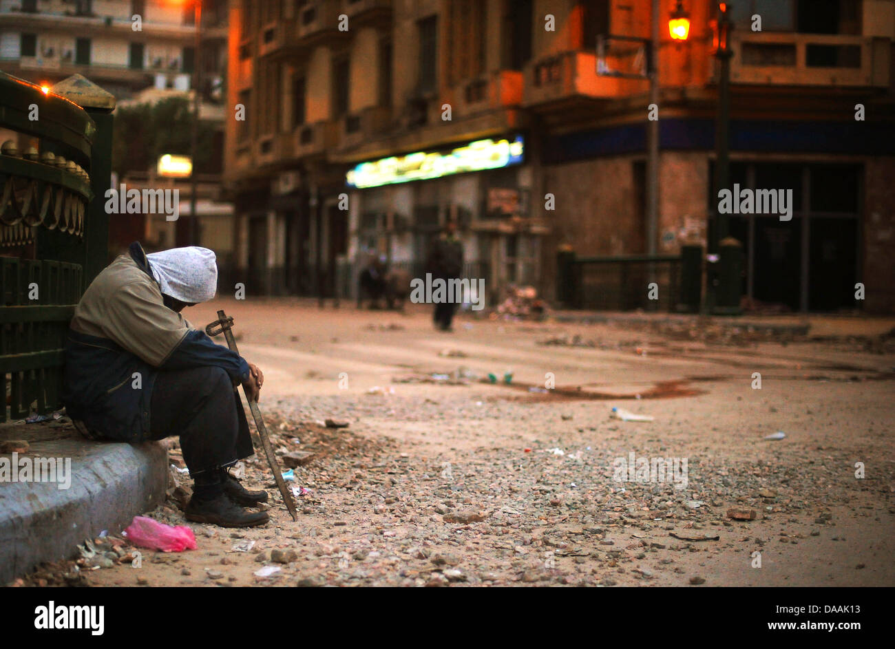 Ein Demonstrant mit einer Eisenstange schläft am Samstagmorgen (05.02.2011) auf dem Tahrir-Platz auf dem Bürgersteig. Tausende Demonstranten übernachteten auf dem Platz. Es kam zu keinen größeren Auseinandersetzungen. Foto: Hannibal dpa Stock Photo