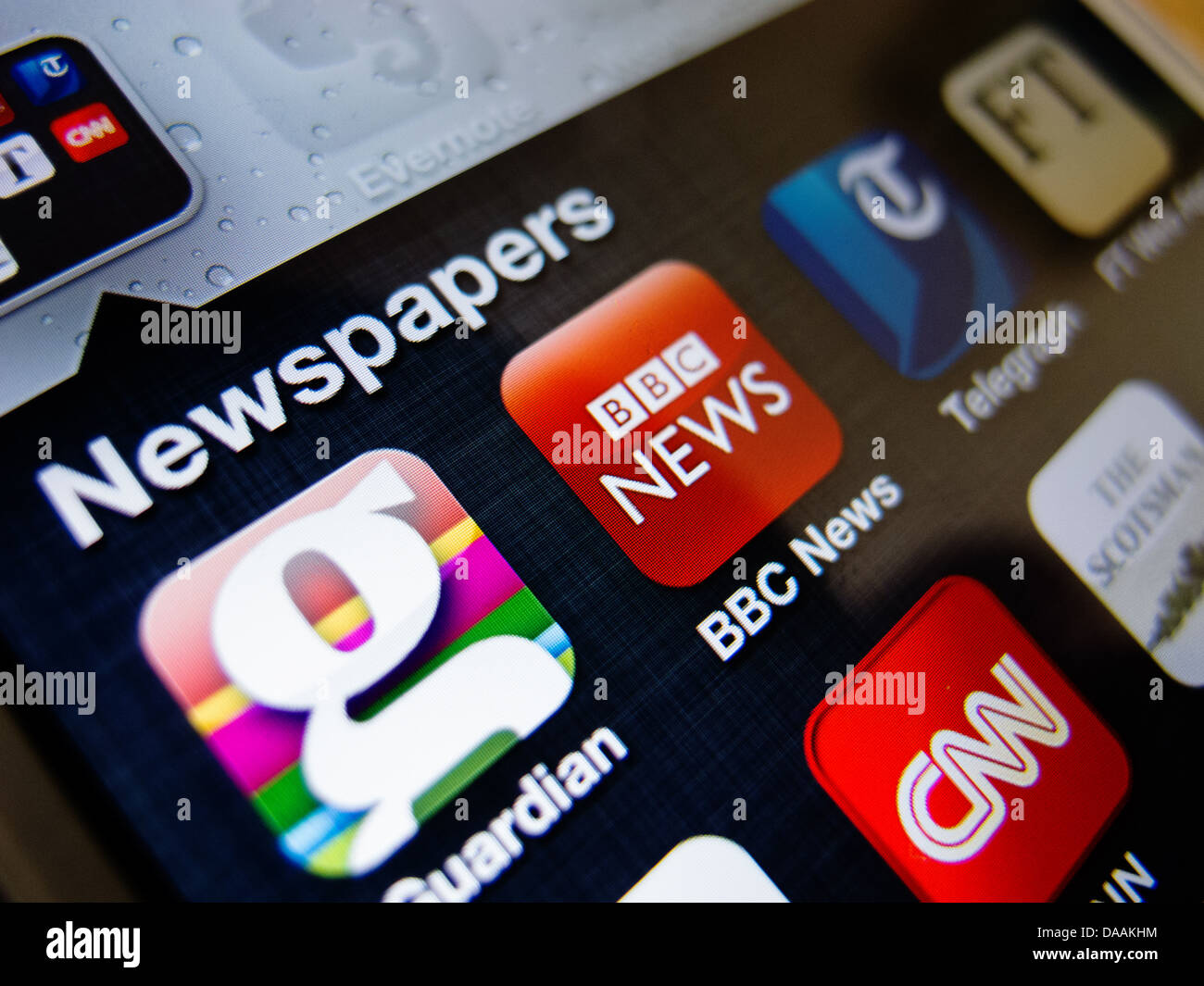 Detail of iPhone 5 smart phone screen showing newspaper apps icons Stock Photo