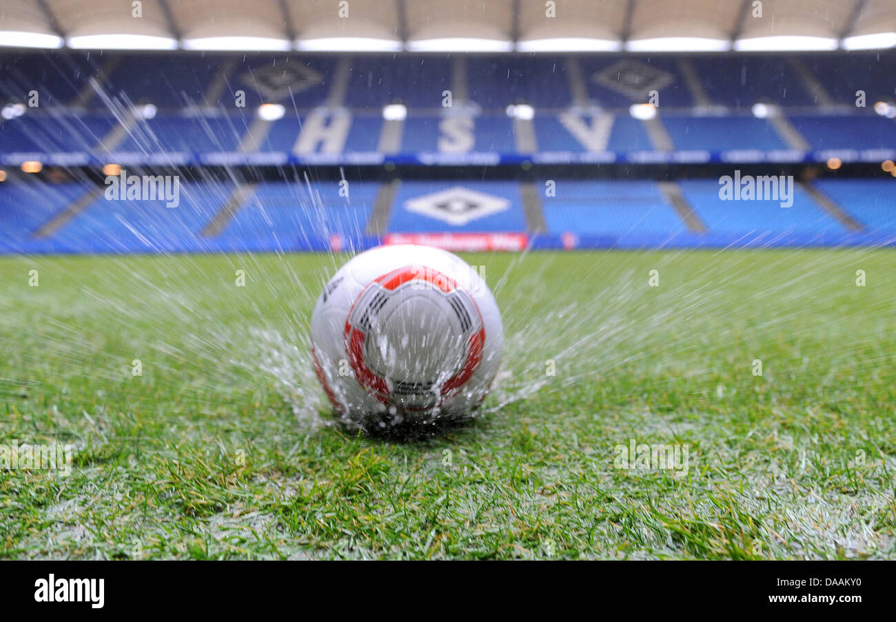 A soccer ball makes a splash as it hits the soaking wet pitch at Imtech Arena in Hamburg, Germany, 06 February 2011. The local Derby between Hamburger SV and FC St. Pauli has been cancelled dcue to havy rain. Photo: Marcus Brandt Stock Photo