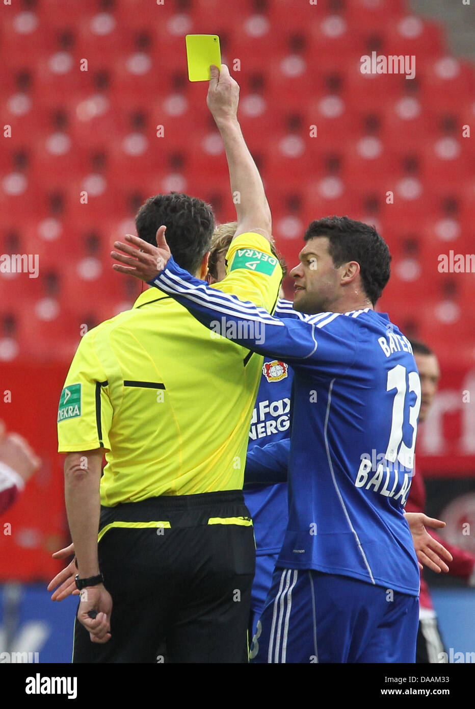 Leverkusen's Michael Ballack (R) argues with the referee Knut Kircher after Ballack's teammate Simon Rolfes (covered, back) recieves the yellow card during the Bundesliga soccer match between 1st FC Nuremberg and Bayer 04 Leverkusen at the easyCredit Stadion in Nuremberg, Germany, 5 February 2011. Photo: Daniel Karmann Stock Photo