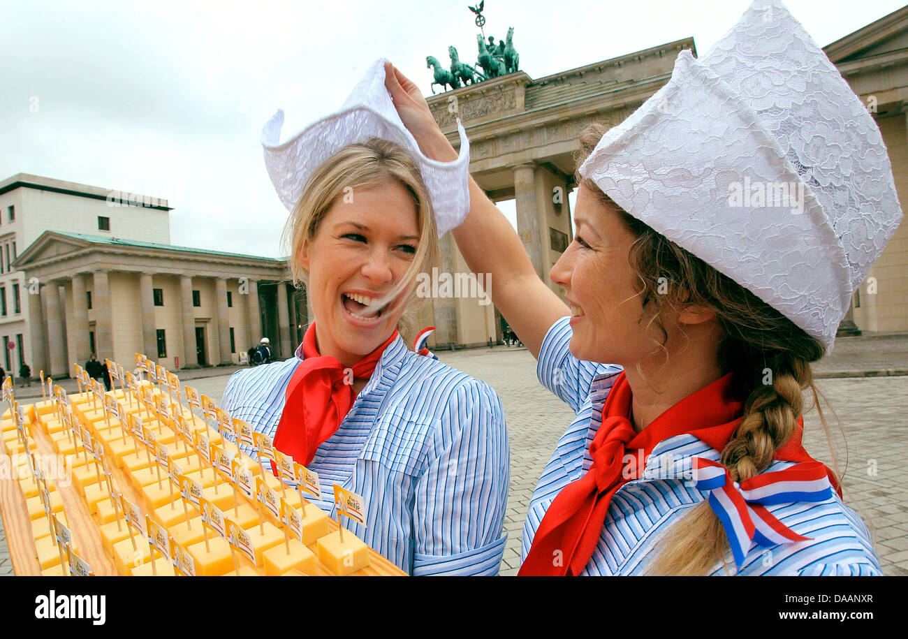 On the occasion of the world's biggest fair for food, agriculture and hortriculture, the International Green Week Berlin, Mandy Smits (L) presents fresh Gouda with her predecessor Madeleen Driessen at the Brandenburg Gate in Berlin, Germany, 20 January 2011. The two women are impersonators of the advertising character 'Frau Antje', representing Dutch dairy. The Green Week last from Stock Photo