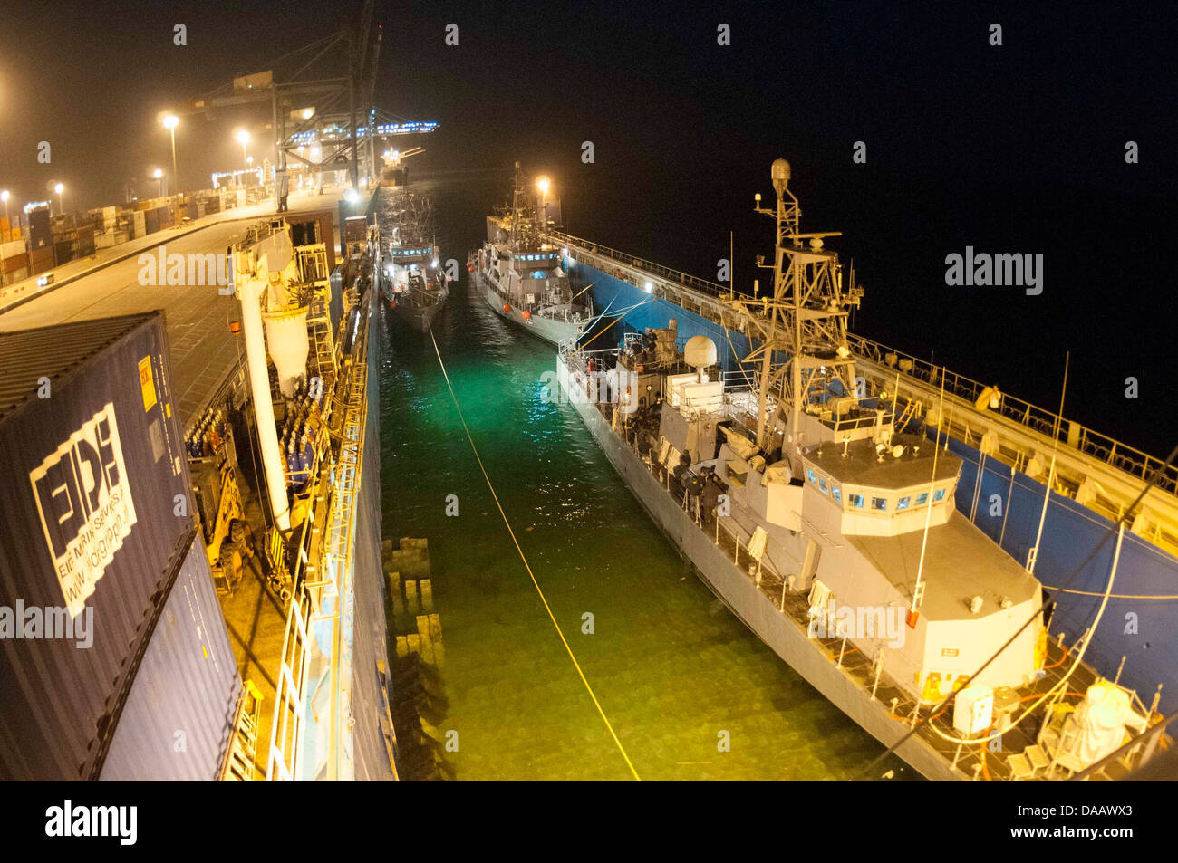 Patrol coastal ship (from left) USS Squall (PC 7), USS Thunderbolt (PC 12), and USS Tempest (PC 2) prepare to float off the motor transport vessel M/V Eide Transporter. The PCs’ arrival brings the total number to eight PCs here to support maritime securit Stock Photo