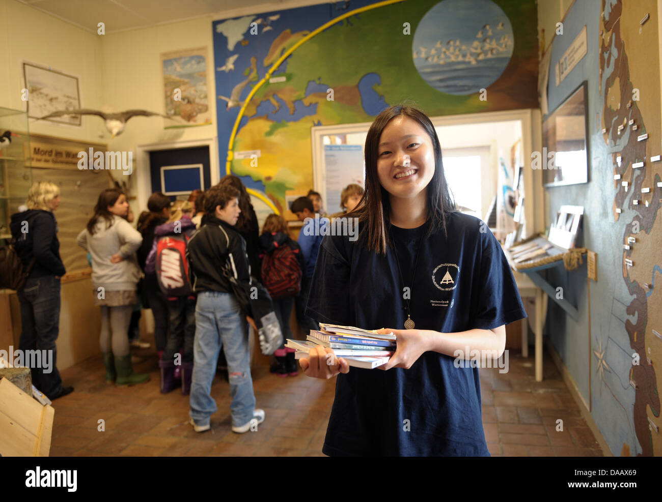 South Korean student, Dschi in Ha, smiles as she stands next to a group of visitors at the Wadden Sea Conservation Station in Hoernum on the island of Sylt, Germany, 15 September 2011. The 22-year old German Studies student  is working a volonteer at the station for two months. Photo: Christian Charisius Stock Photo