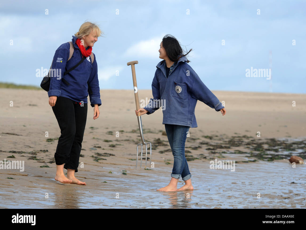 South Korean student, Dschi in Ha, and head of the Wadden Sea Conservation Station, Kirsten Thiemann (L), walk across the tidelands in Hoernum on the island of Sylt, Germany, 15 September 2011. The 22-year old German Studies student  is working a volonteer at the station for two months. Photo: Christian Charisius Stock Photo
