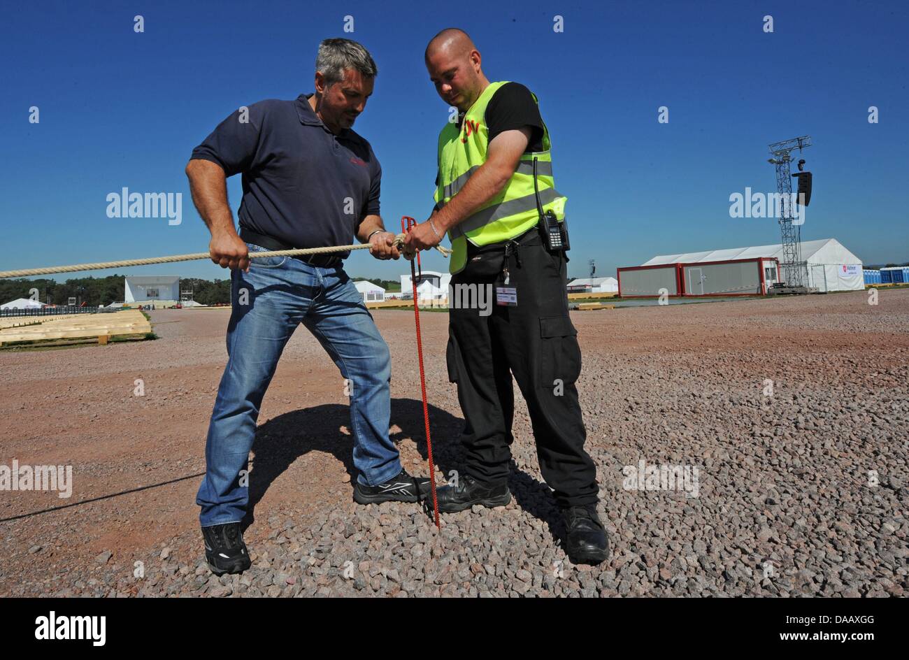 Barny Sancakli (L), head of a security company in Ulm, sets up a security cordon with his employee Alexander Schmidt (R) at the airport in Freiburg, Germany, 21 September 2011. On Sunday, 25 September 2011, the pope will give a mass with more than 100,000 people here. Photo: PATRICK SEEGER Stock Photo