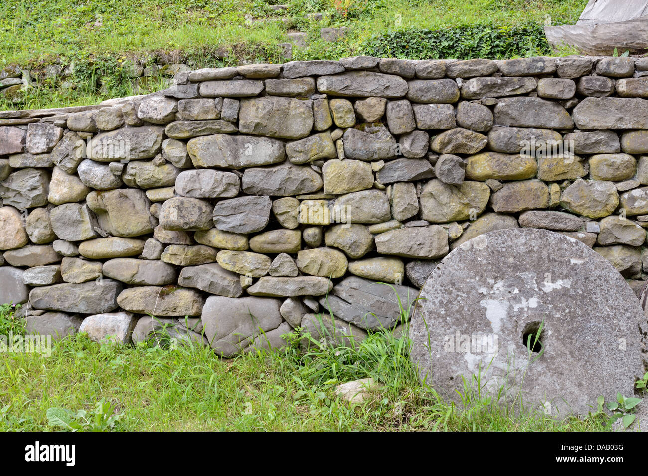 Stone wall and green grass in the backyard Stock Photo - Alamy