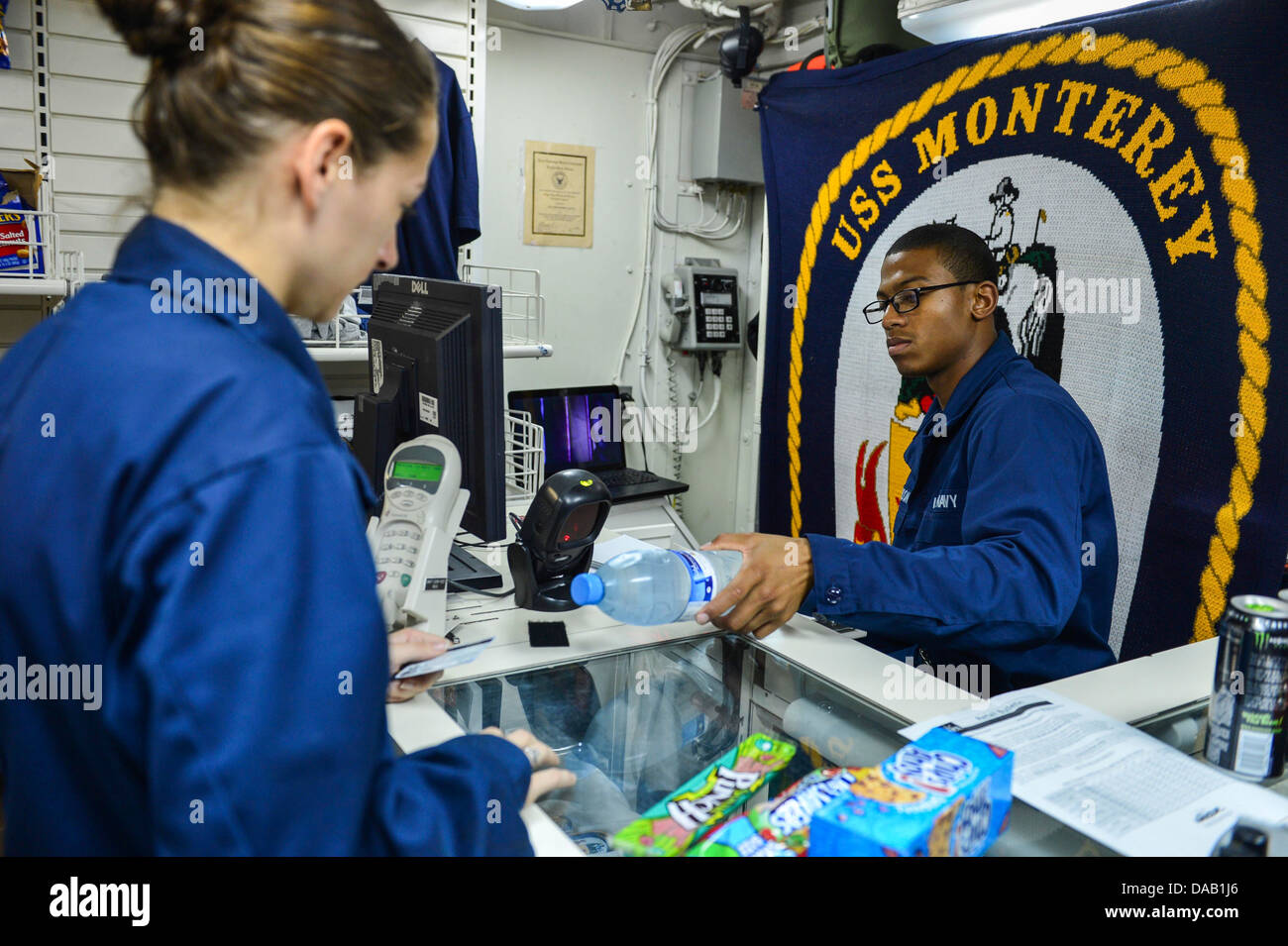 Seaman Apprentice Quinton Harrison conducts a sale for Ensign Kimberly Robillard in the ship store aboard the guided-missile cruiser USS Monterey (CG 61). Monterey is deployed in support of maritime security operations and theater security cooperation eff Stock Photo