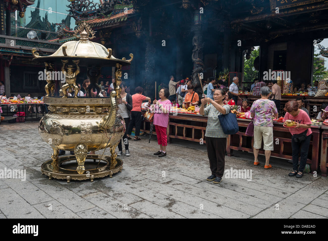 Buddhist and Taoist worshippers burning incense sticks as a ritual