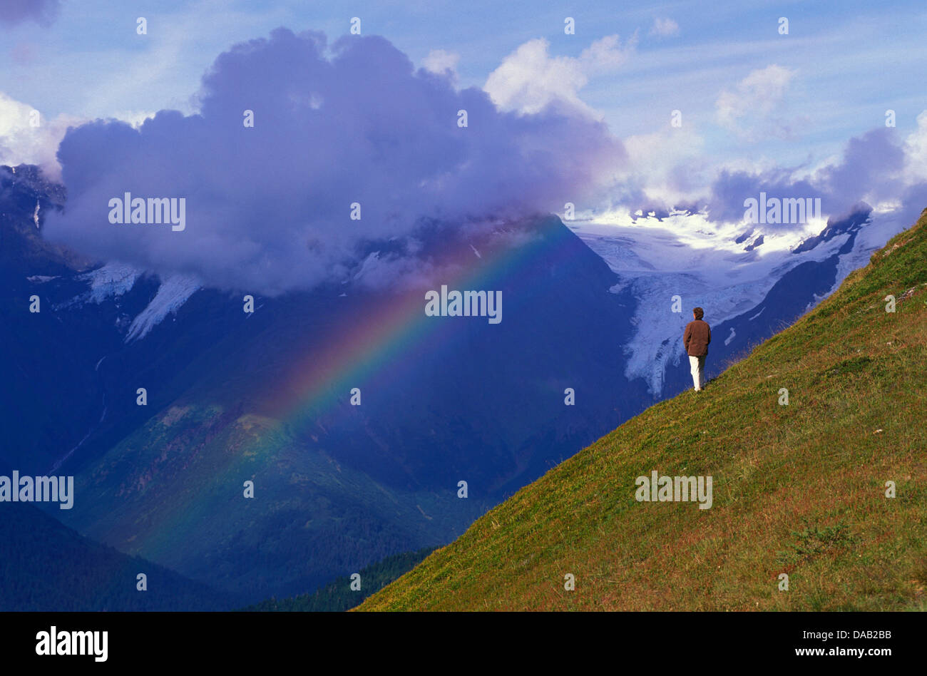 Chugach Mountains, The Alyeska Prince Hotel, Girdwood, Alaska, USA, rainbow, person, site seeing, clouds, sunny, cold, snow Stock Photo