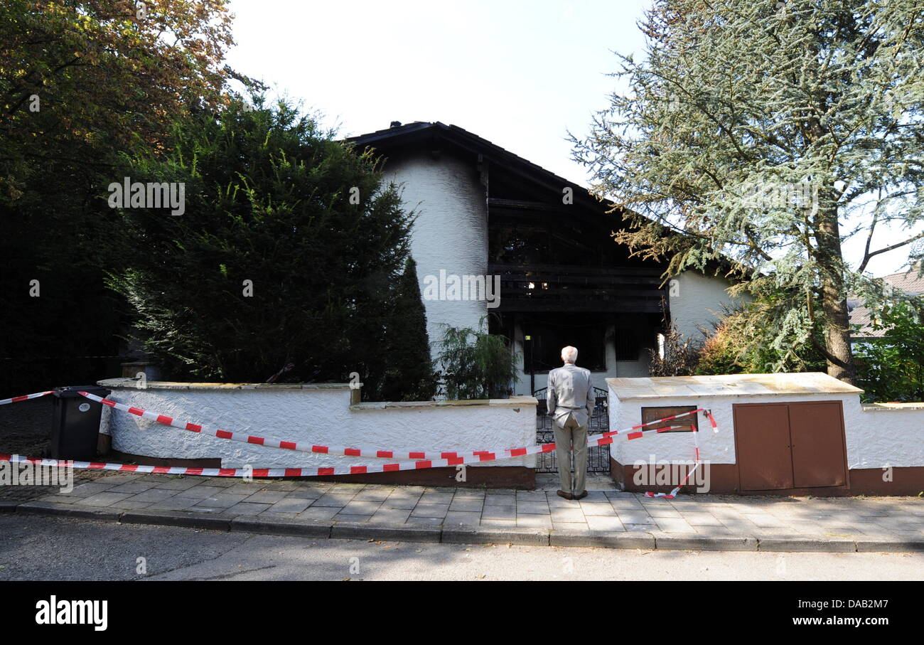 Ein Mann betrachtet am Sonntag (25.09.2011) in Grünwald bei München (Oberbayern) das ausgebrannte Haus des Fußballspielers Breno. Der brasilianische Fußballprofi und Spieler des FC Bayern, Breno, wurde wegen des Verdachts auf schwere Brandstiftung in Untersuchungshaft genommen. Foto: Tobias Hase dpa/lby Stock Photo