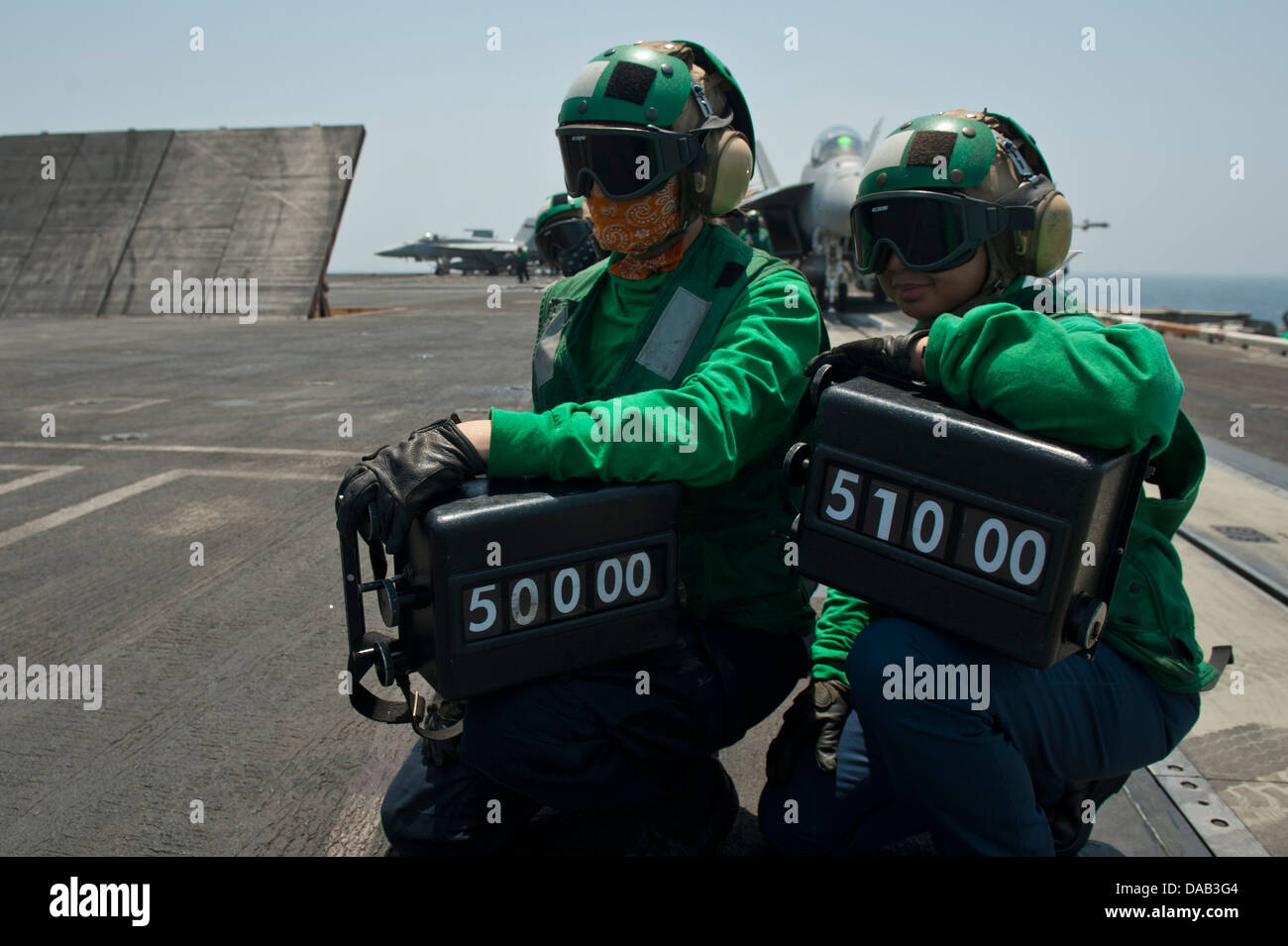 Sailors hold weight boards as fixed-wing aircraft launch from the aircraft carrier USS Nimitz (CVN 68). The Nimitz Carrier Strike Group is deployed to the U.S. 5th Fleet area of responsibility conducting maritime security operations, theater security coop Stock Photo