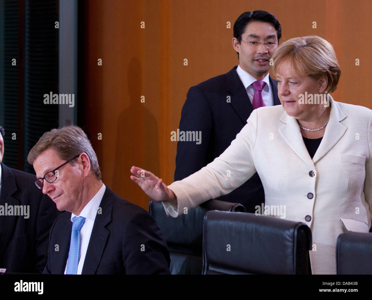 German Chancellor Angela Merkel welcomes  Guido Westerwelle (L) prior to the cabinet's meeting in the chancellory in Berlin, Germany, 27 September 2011. In the center Economy Minister and Vice Chancellor Philipp Roesler is pictured. Among others, the euro debt crisis was discussed. Photo: HERBERT KNOSOWSKI Stock Photo