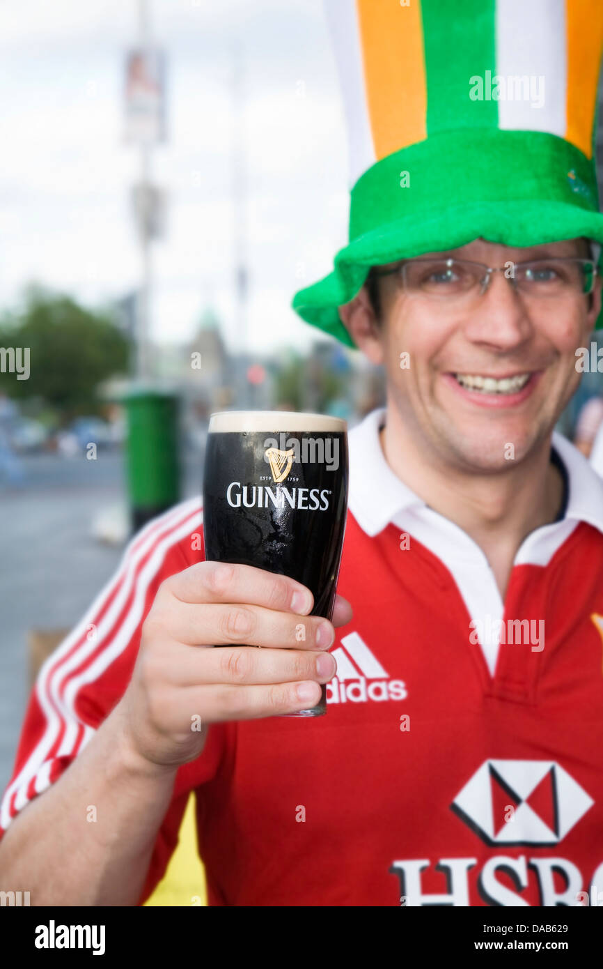Man drinking a pint of Guinness stout beer on a Stag weekend in Dublin, Eire / Ireland. Background has been digitally blurred. Stock Photo