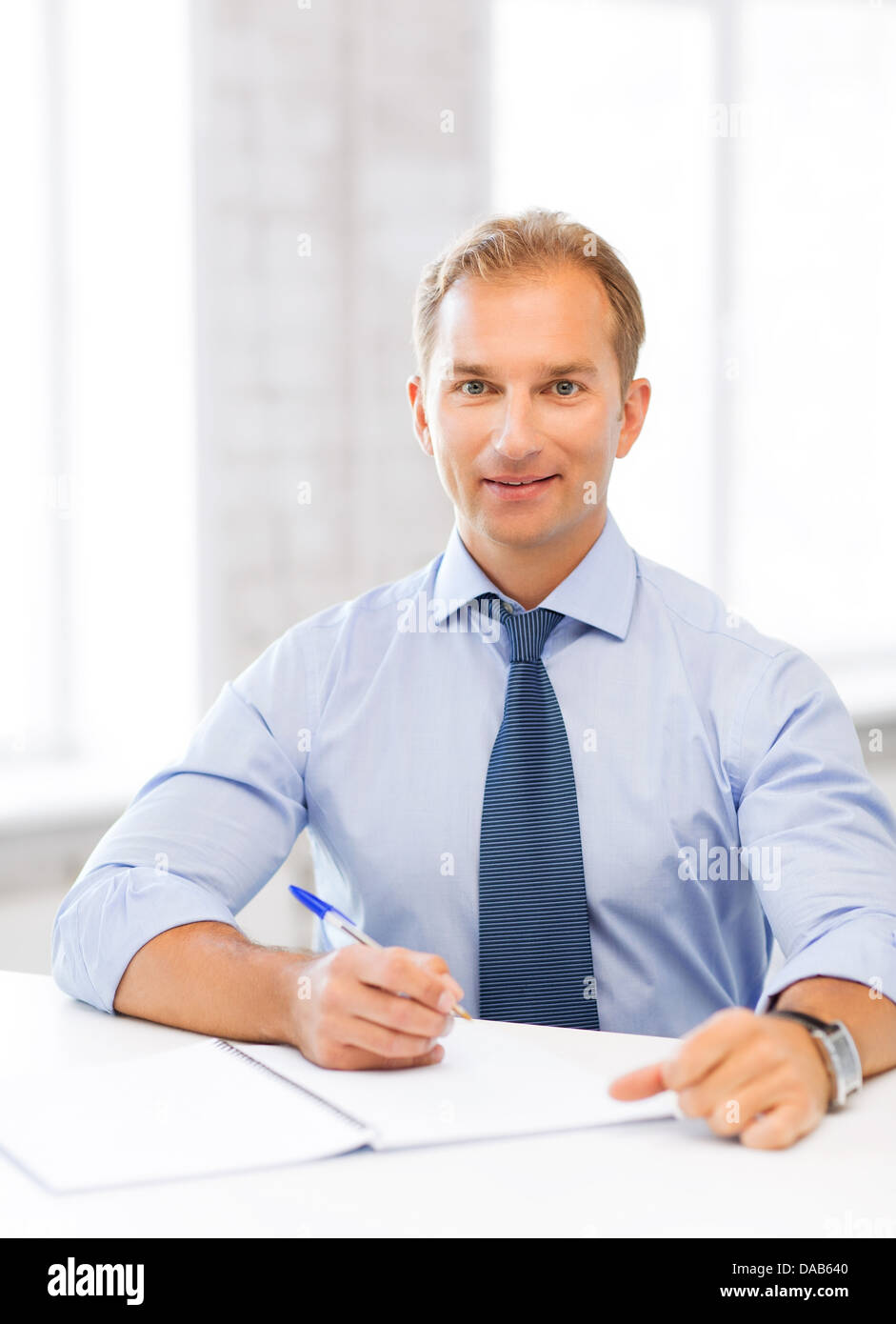handsome businessman writing in notebook Stock Photo