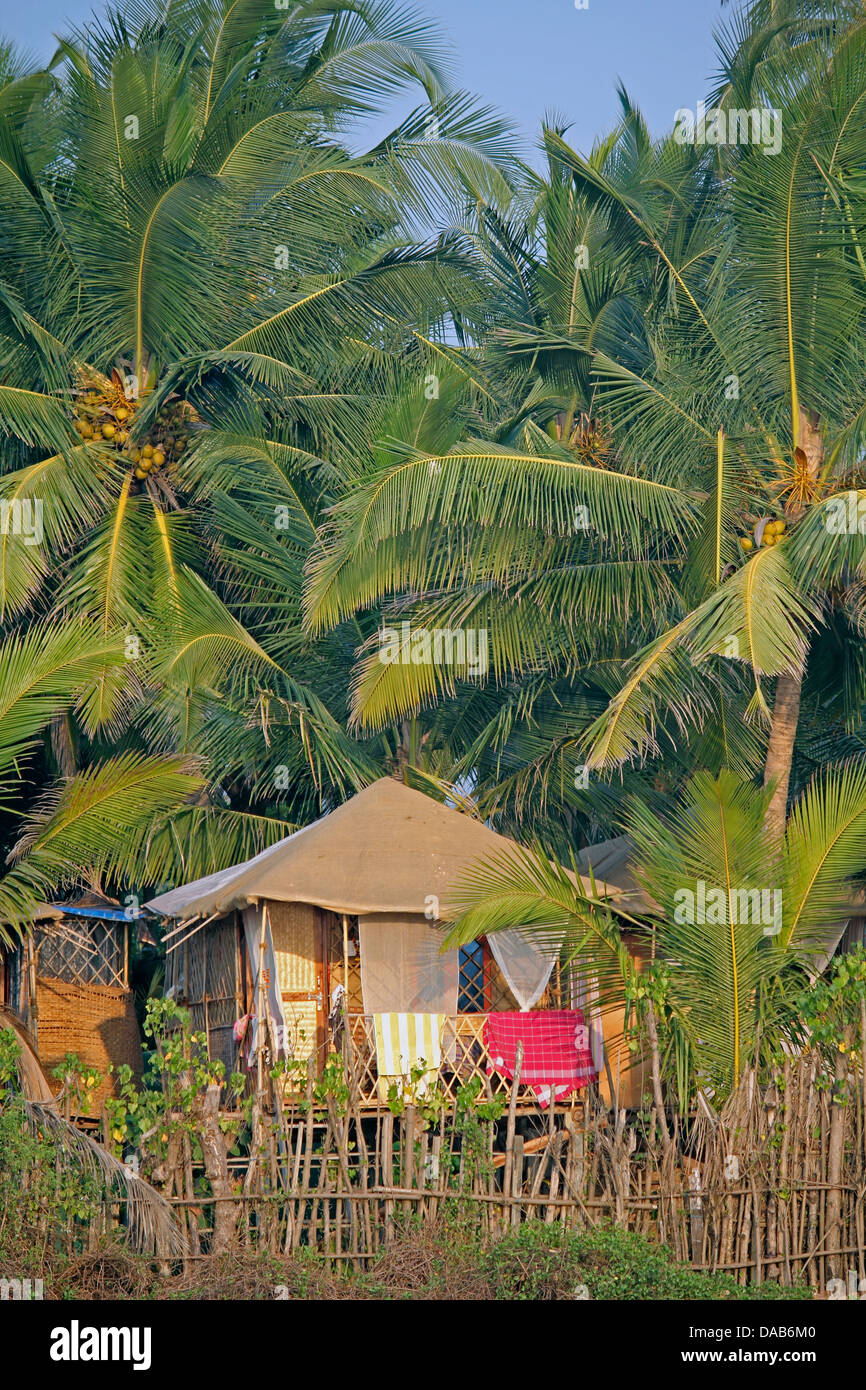 Cocohut beach holiday bungalows on stilts Agonda beach, Goa India Stock Photo