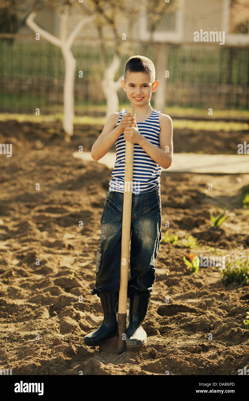 little happy boy working with shovel in garden Stock Photo - Alamy