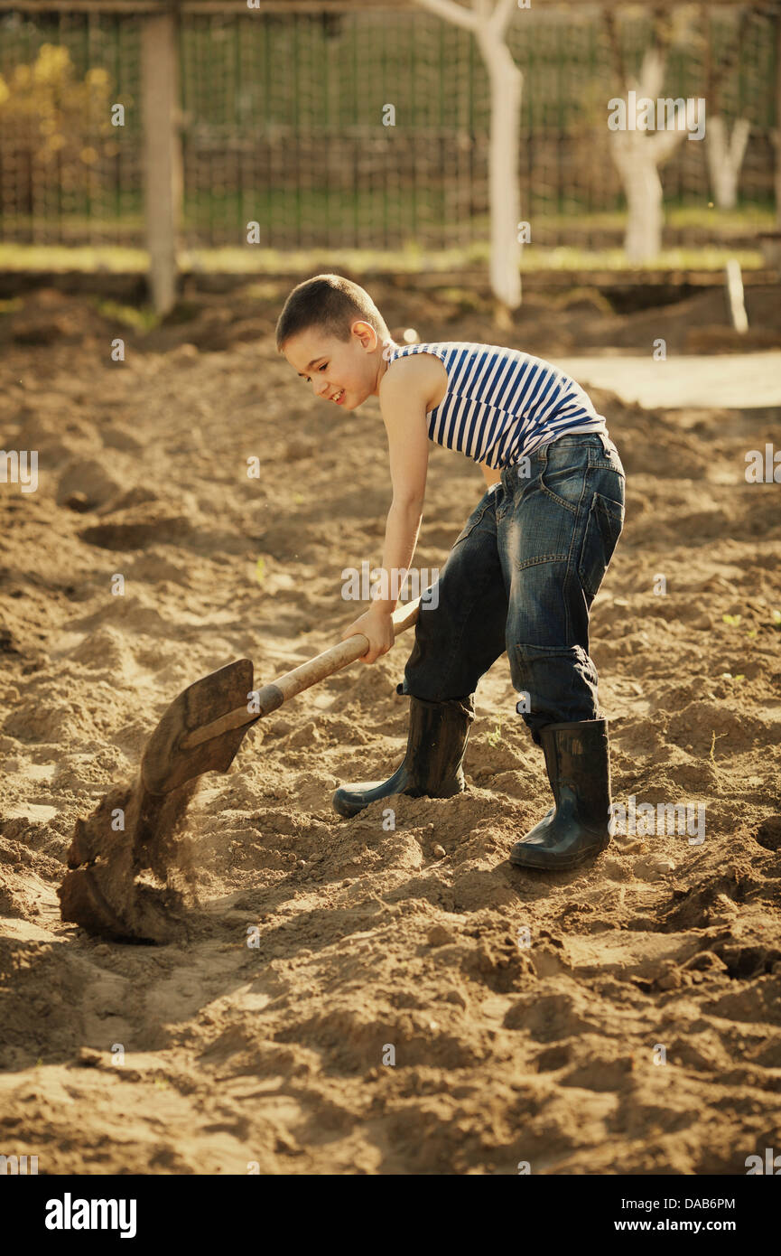 little happy boy working with shovel in garden Stock Photo - Alamy
