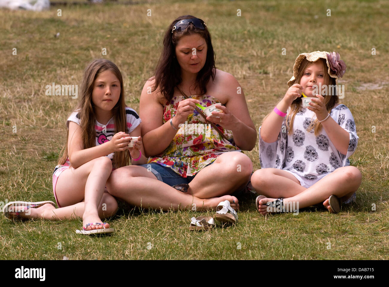 People eating ice cream and enjoying British summer time, The Heath, Petersfield, Hampshire, UK. Stock Photo