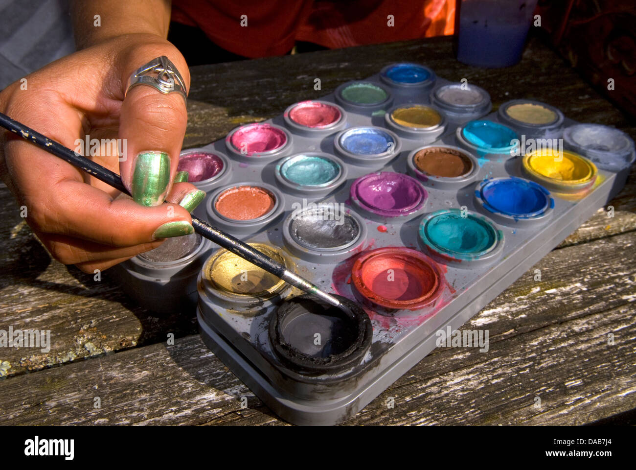 Paint palette on plate and glass containing brushes Stock Photo - Alamy