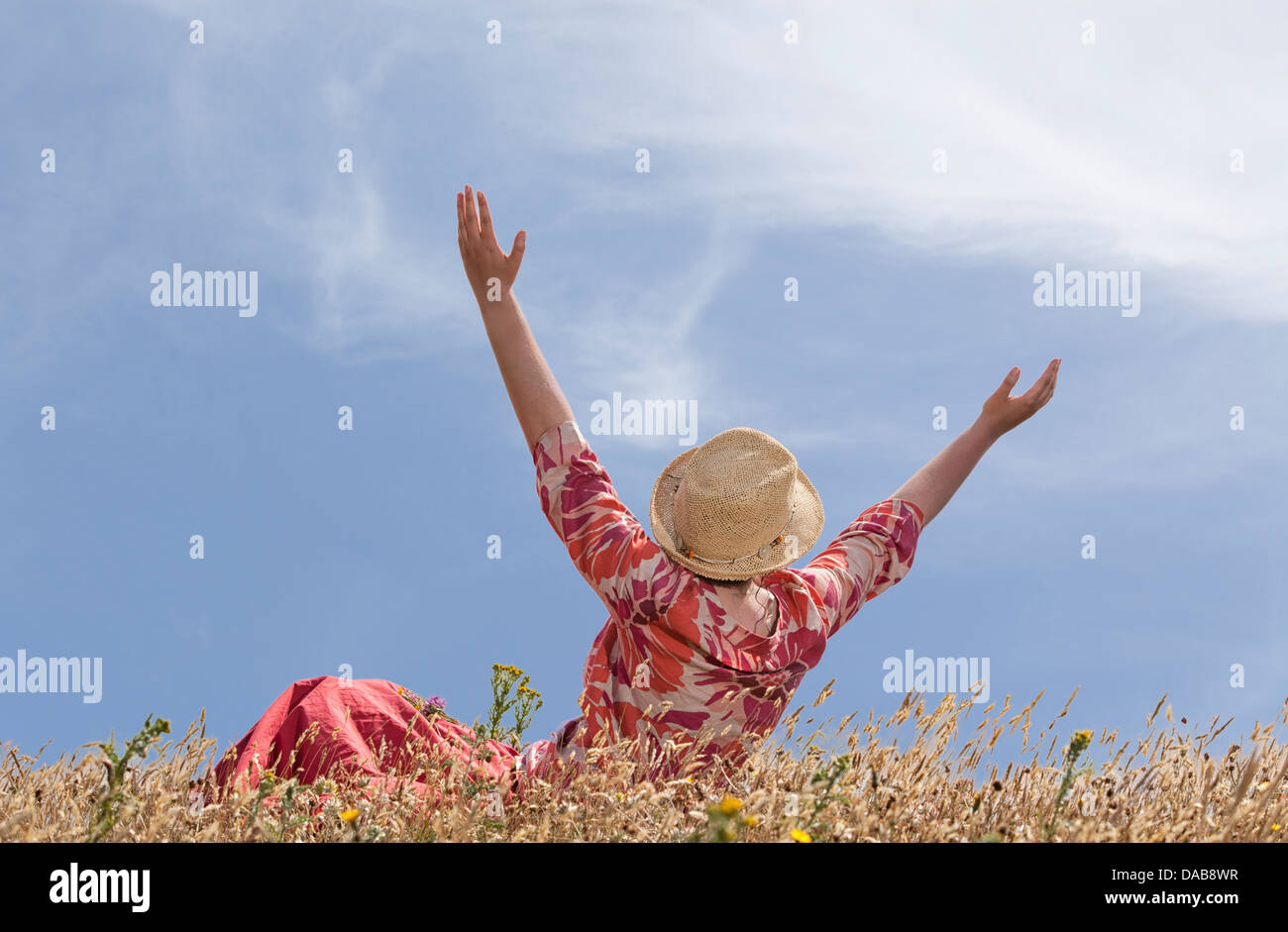 Woman with hands raised toward heaven Stock Photo