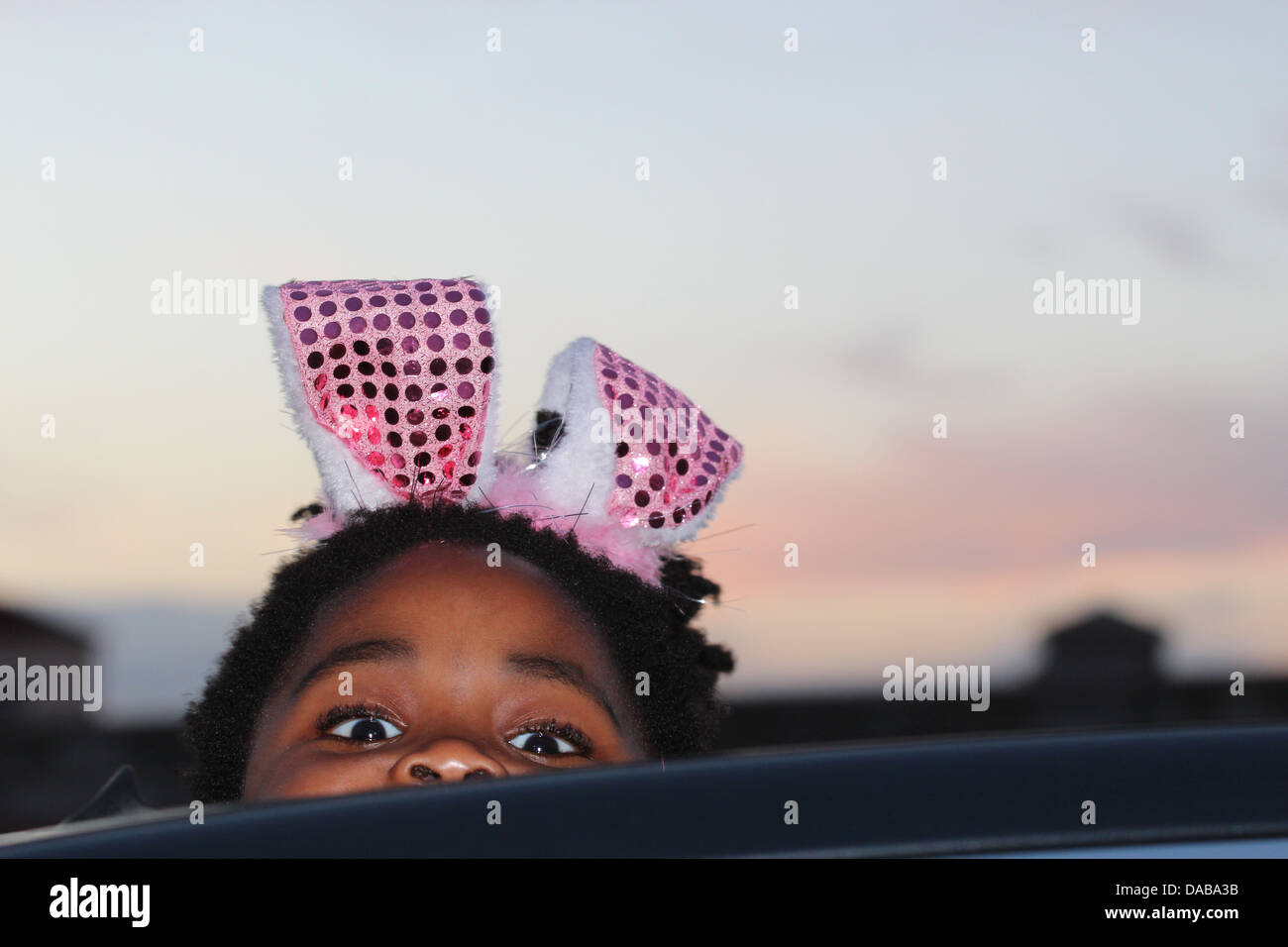 Baby girl peaking though a sunroof at sunset Stock Photo Alamy