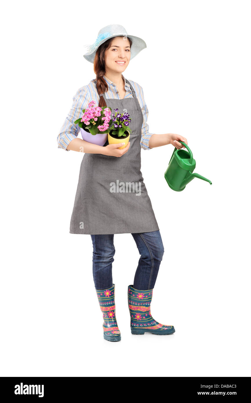 Full length portrait of a female gardener holding flower pots and ...