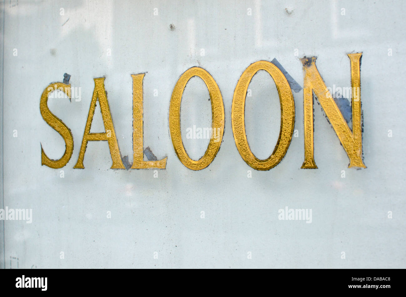Close-up of an old 'Saloon' sign on a pub window Stock Photo