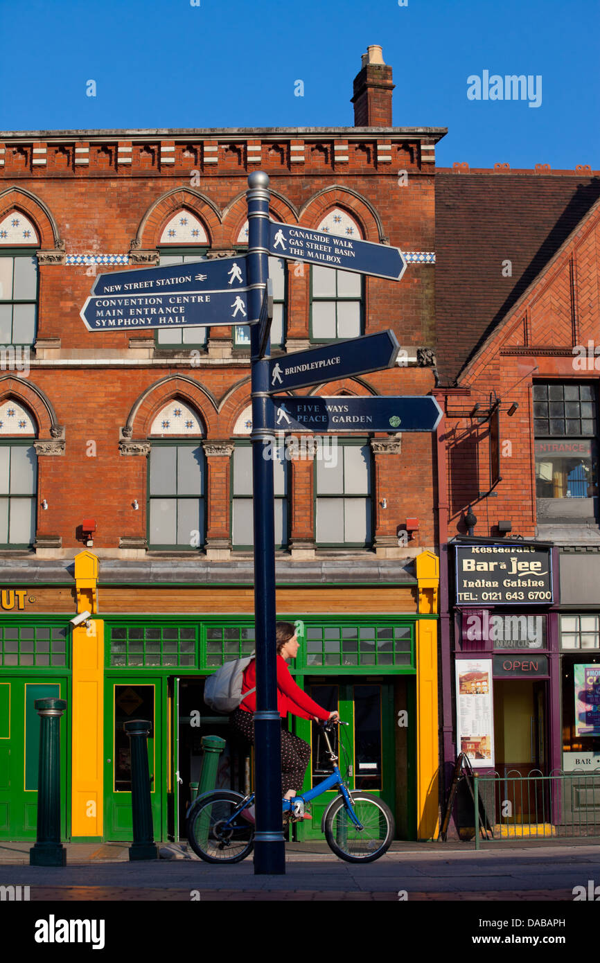 Fingerpost on Broad Street Birmingham UK with a cyclist in the middle ground Stock Photo