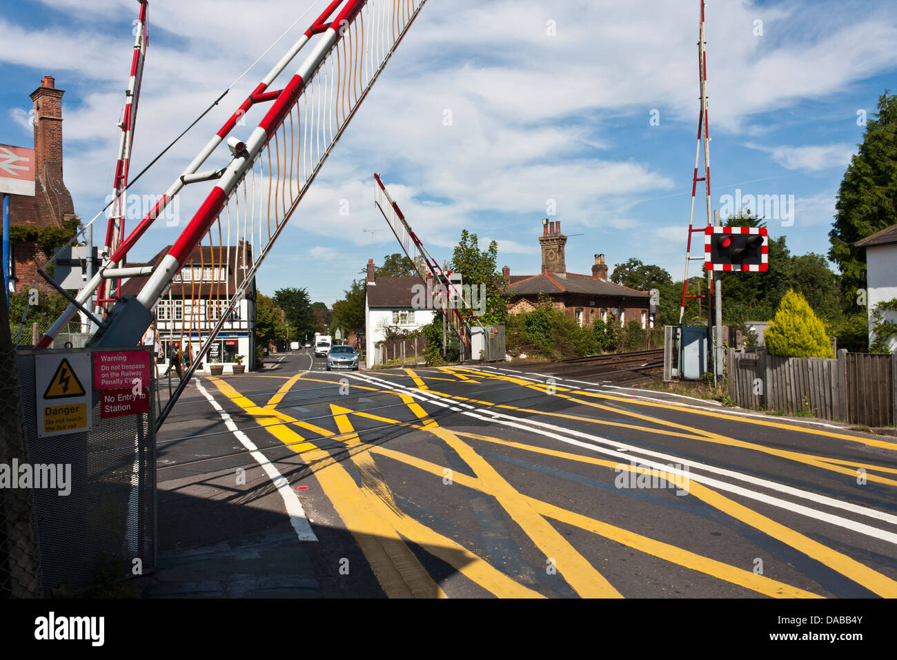 Barriers fall at an English level crossing as a train approaches in the New Forest,.Brockenhurst, Hampshire, England, GB, UK Stock Photo