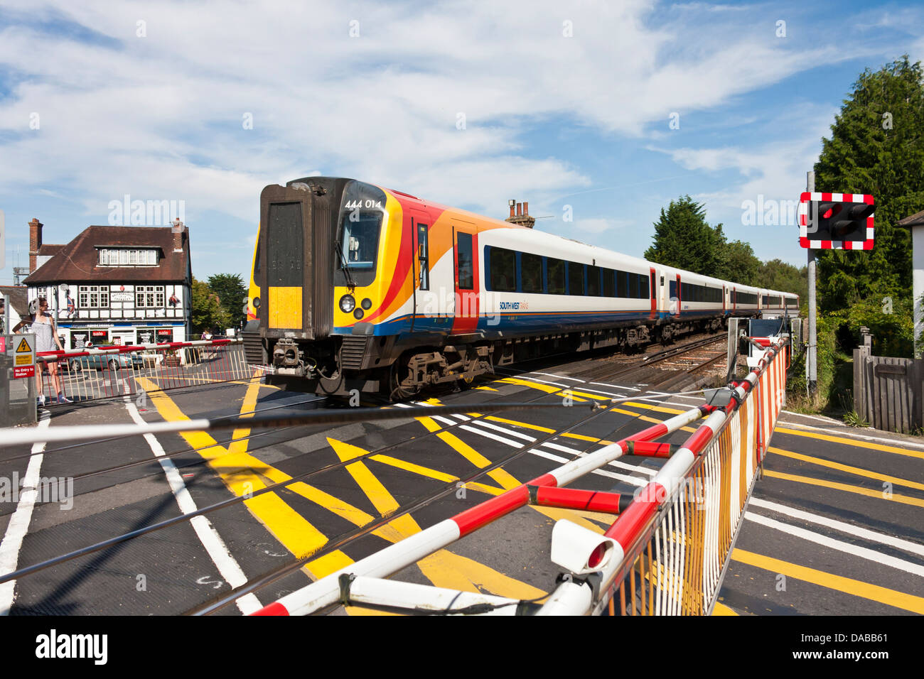 Barriers are down at an English level crossing as a train passes in the New Forest,.Brockenhurst, Hampshire, England, GB, UK Stock Photo