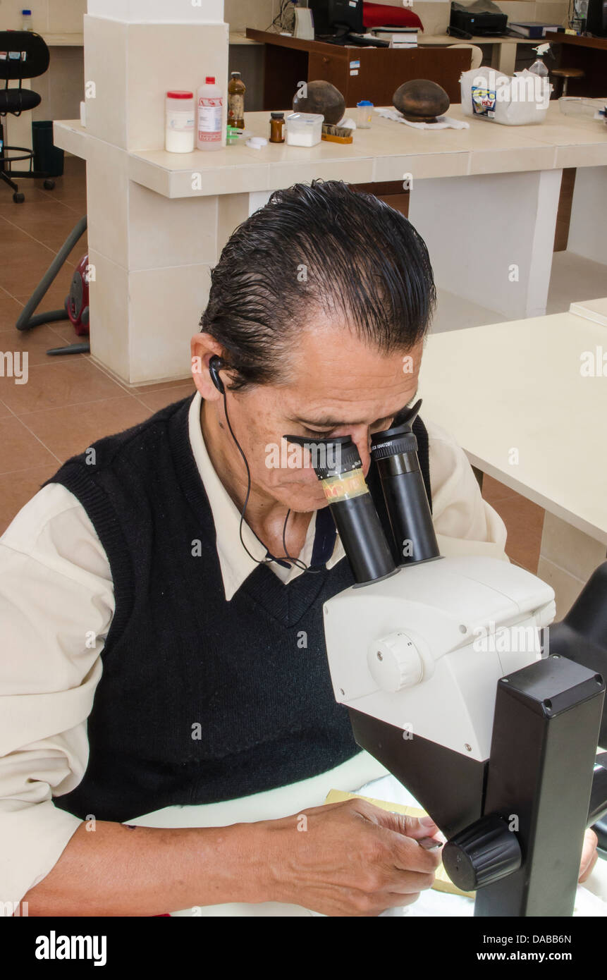 Worker restorer microscope restoring rare ancient artifacts at Museum of the Royal Tombs of Sipan, Chiclayo Lambayeque, Peru. Stock Photo