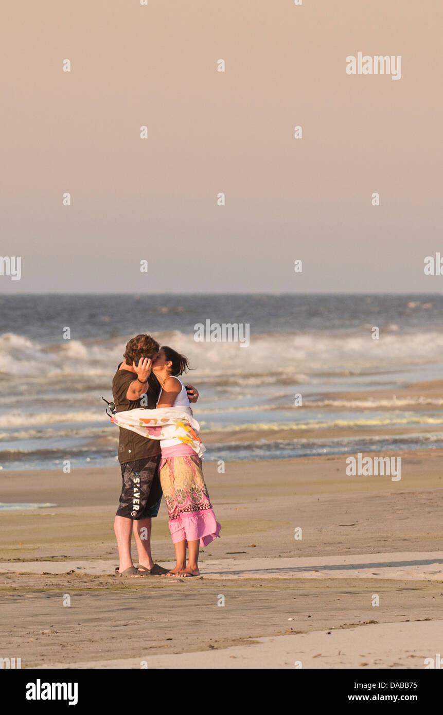 Couple sharing a romantic kiss kissing and taking picture on Vichayito beach at sunset, Mancora, Peru. Stock Photo