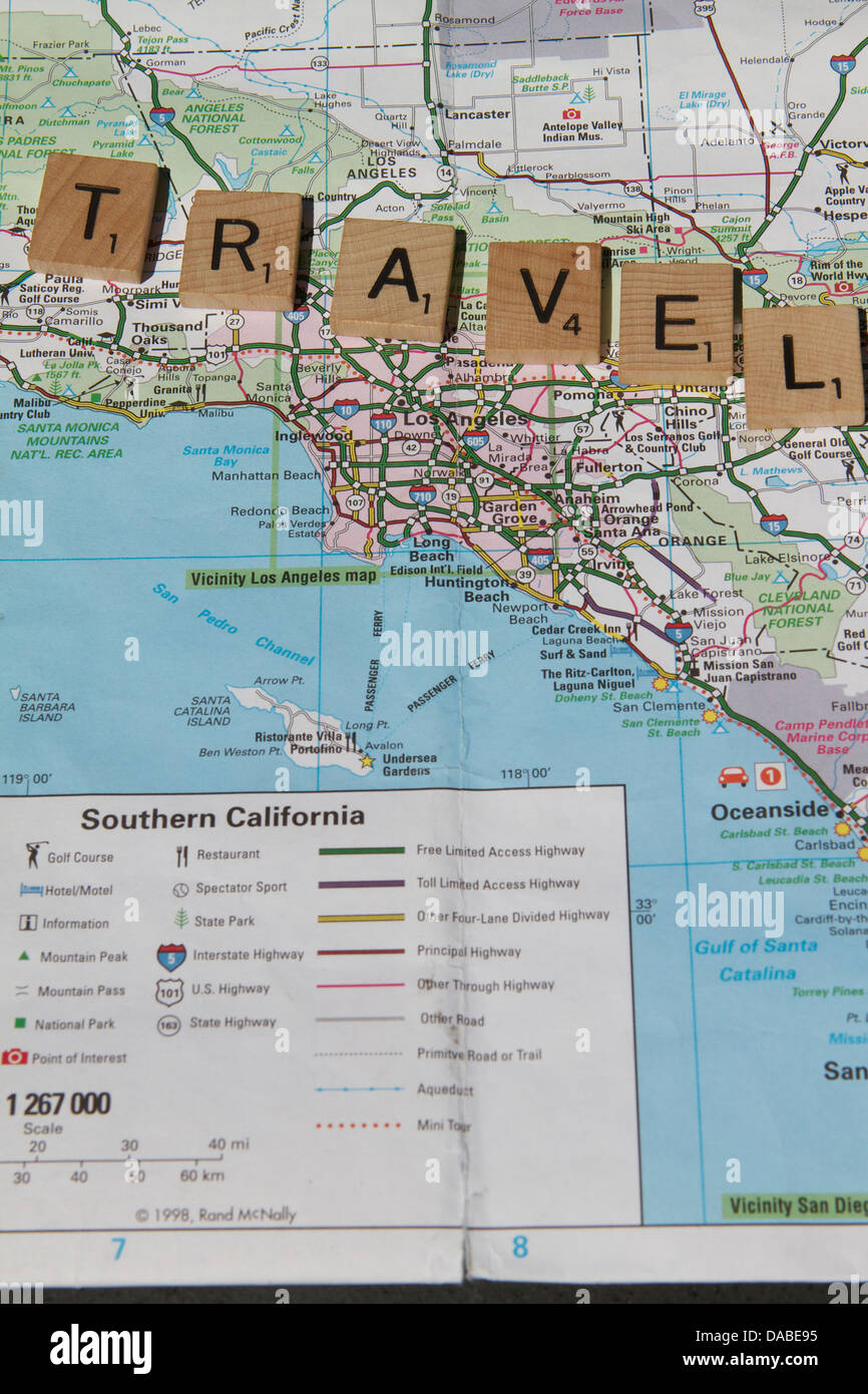 The word travel spelt  out on wooded game blocks on a map of California USA Stock Photo
