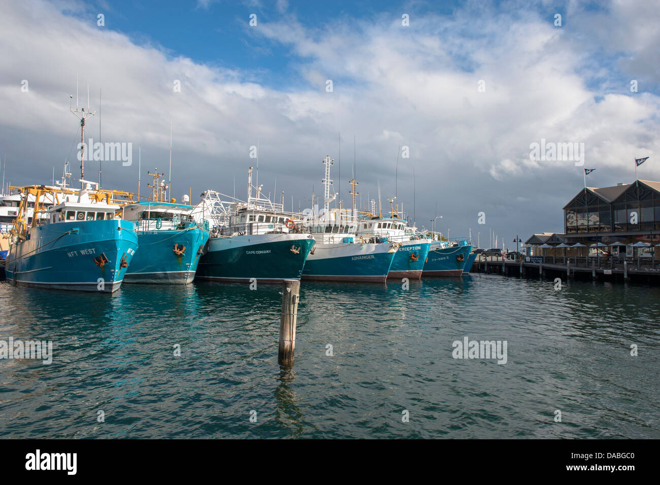Fishing trawlers at the Fremantle Fishing Boat Harbour, Western Australia, with rainy showers