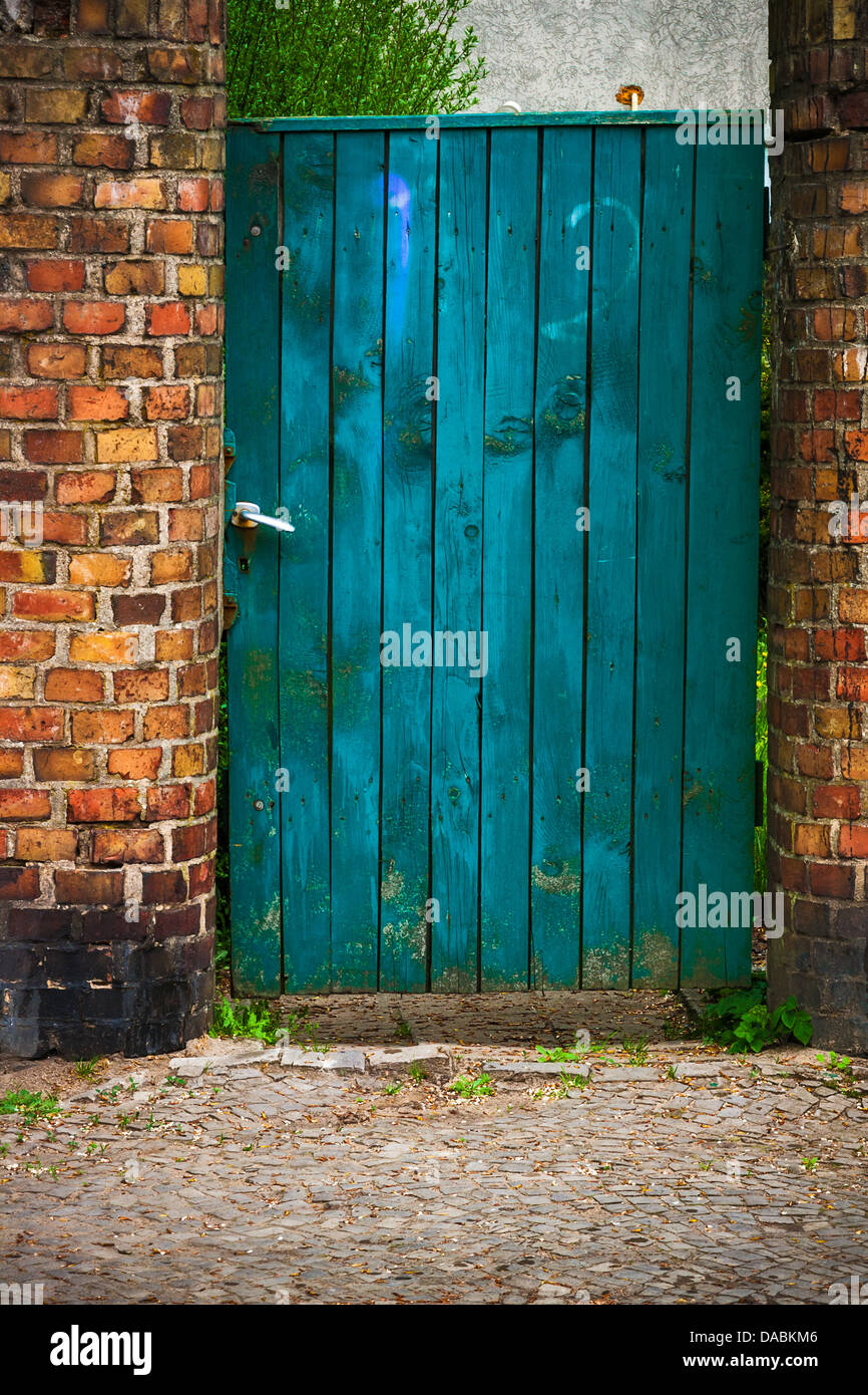 Old door wicket gate in a brick wall Stock Photo