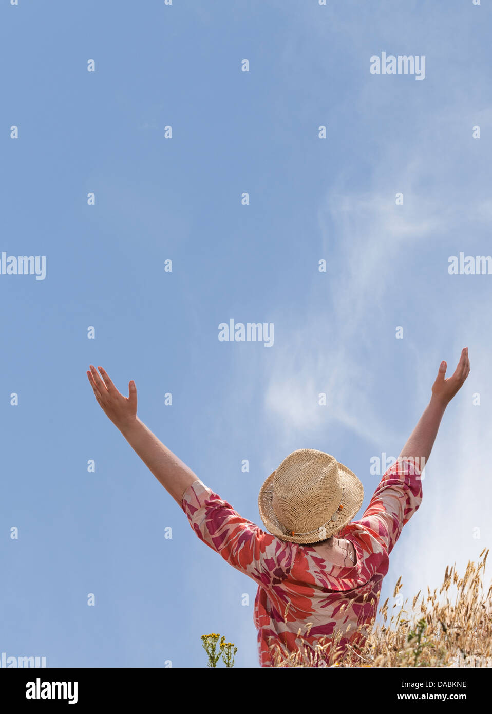 Woman with hands raised toward heaven Stock Photo