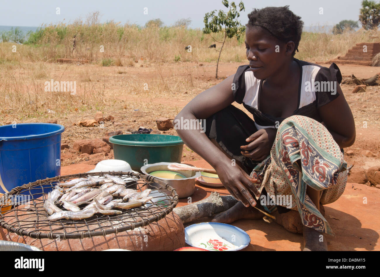 Lady preparing fish for meal, Talpia, Zambia, Africa Stock Photo