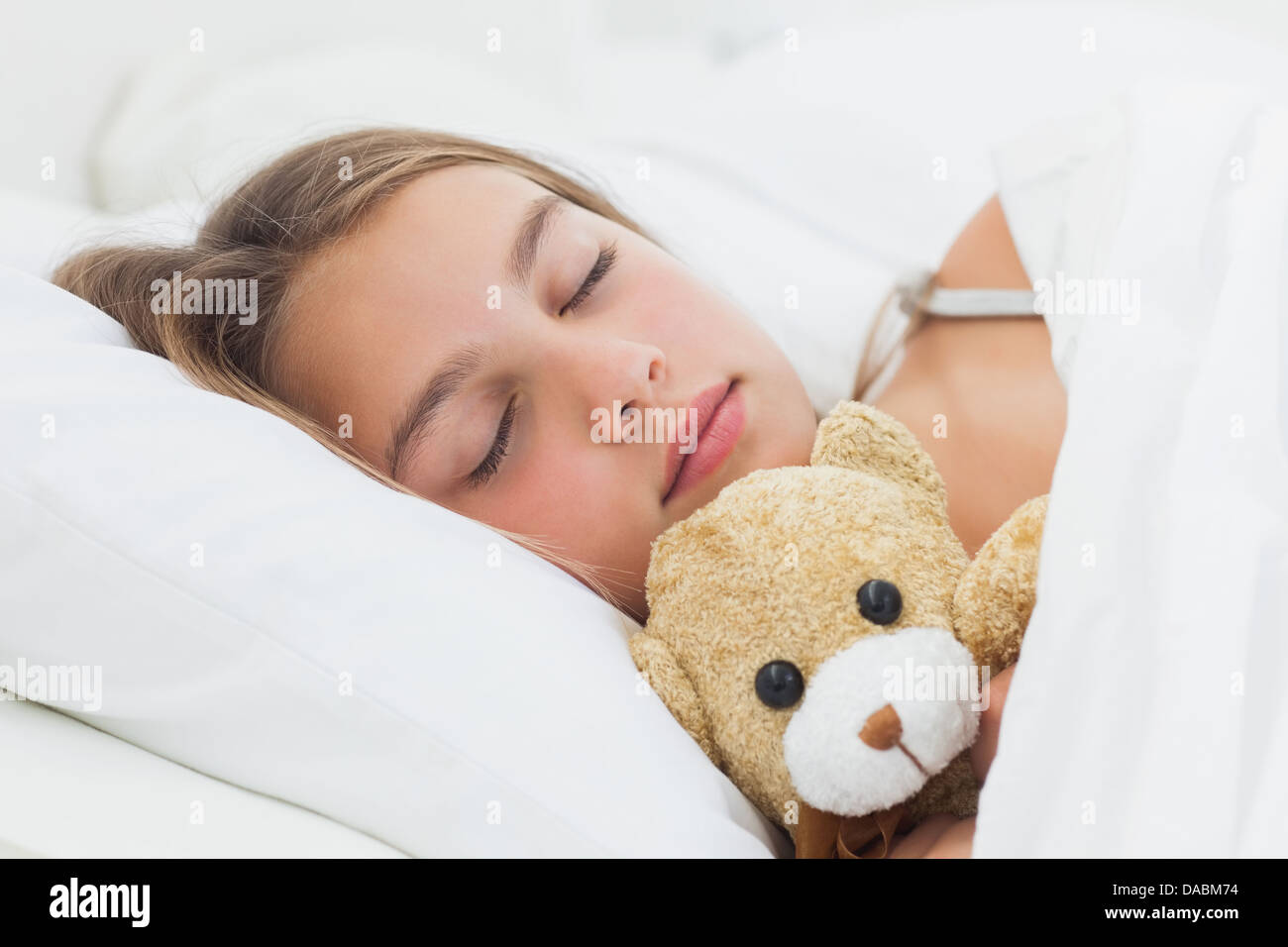 Cheerful girl sleeping with her teddy bear Stock Photo - Alamy