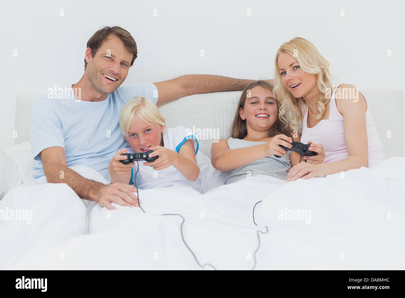 Family playing video games in bed Stock Photo Alamy