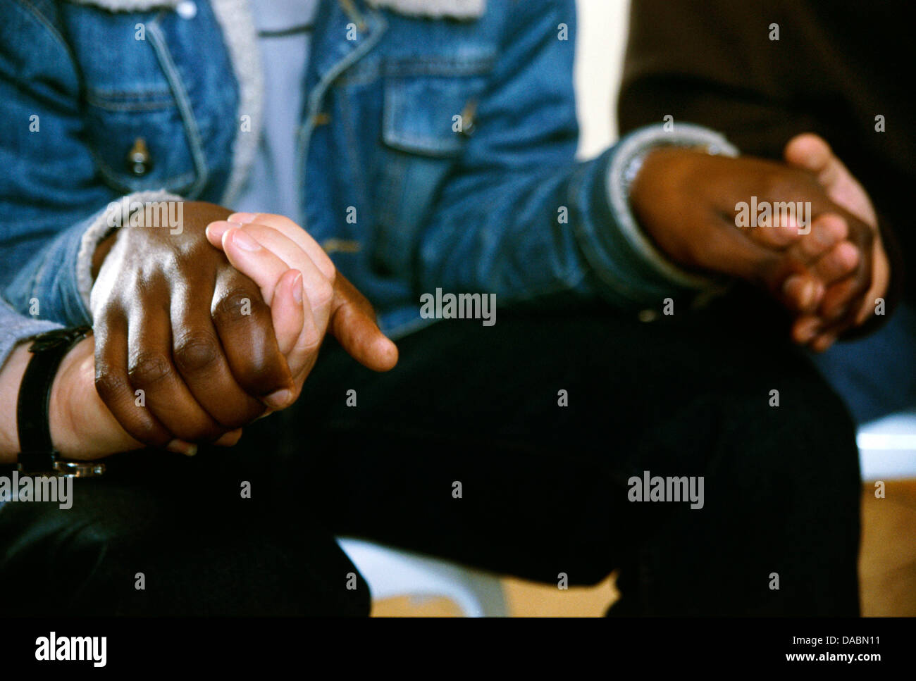 Hydrologist Nick Walker (left) mountain guide Geoff Gould (right) hold hand administrator Siphiwe Dhlamini as they pray during Stock Photo