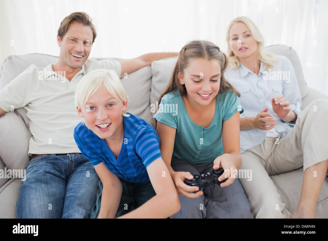 Children playing video games on the couch Stock Photo Alamy