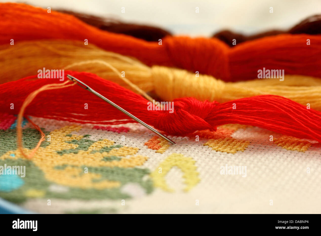 a tangle of colored threads for embroidery and needle Stock Photo - Alamy