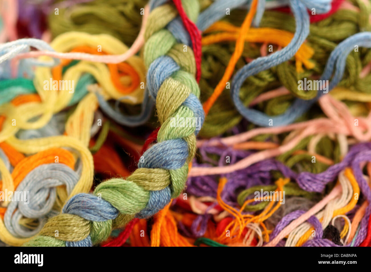 a tangle of colored threads for embroidery and needle Stock Photo - Alamy