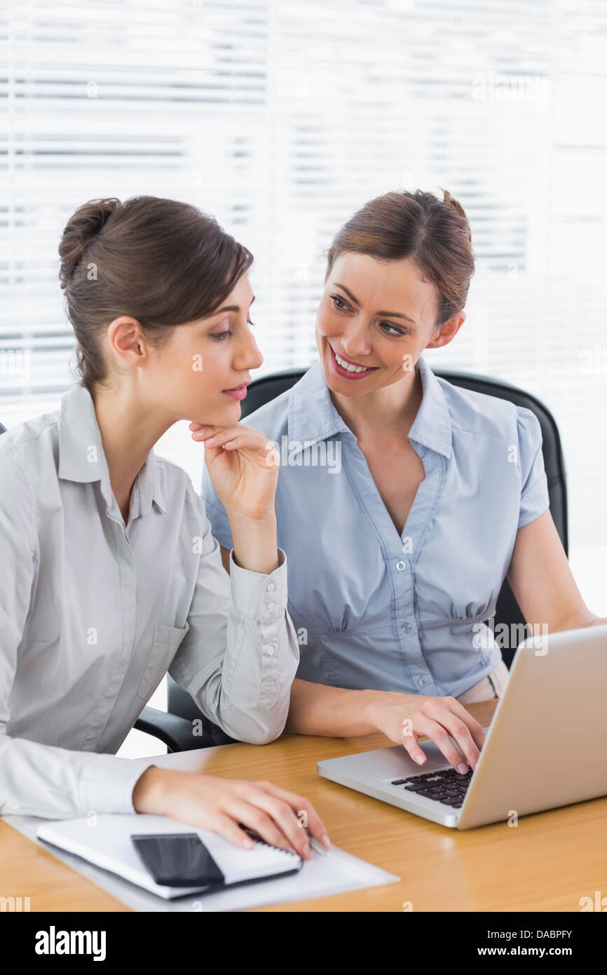 Businesswomen working together on a laptop Stock Photo - Alamy