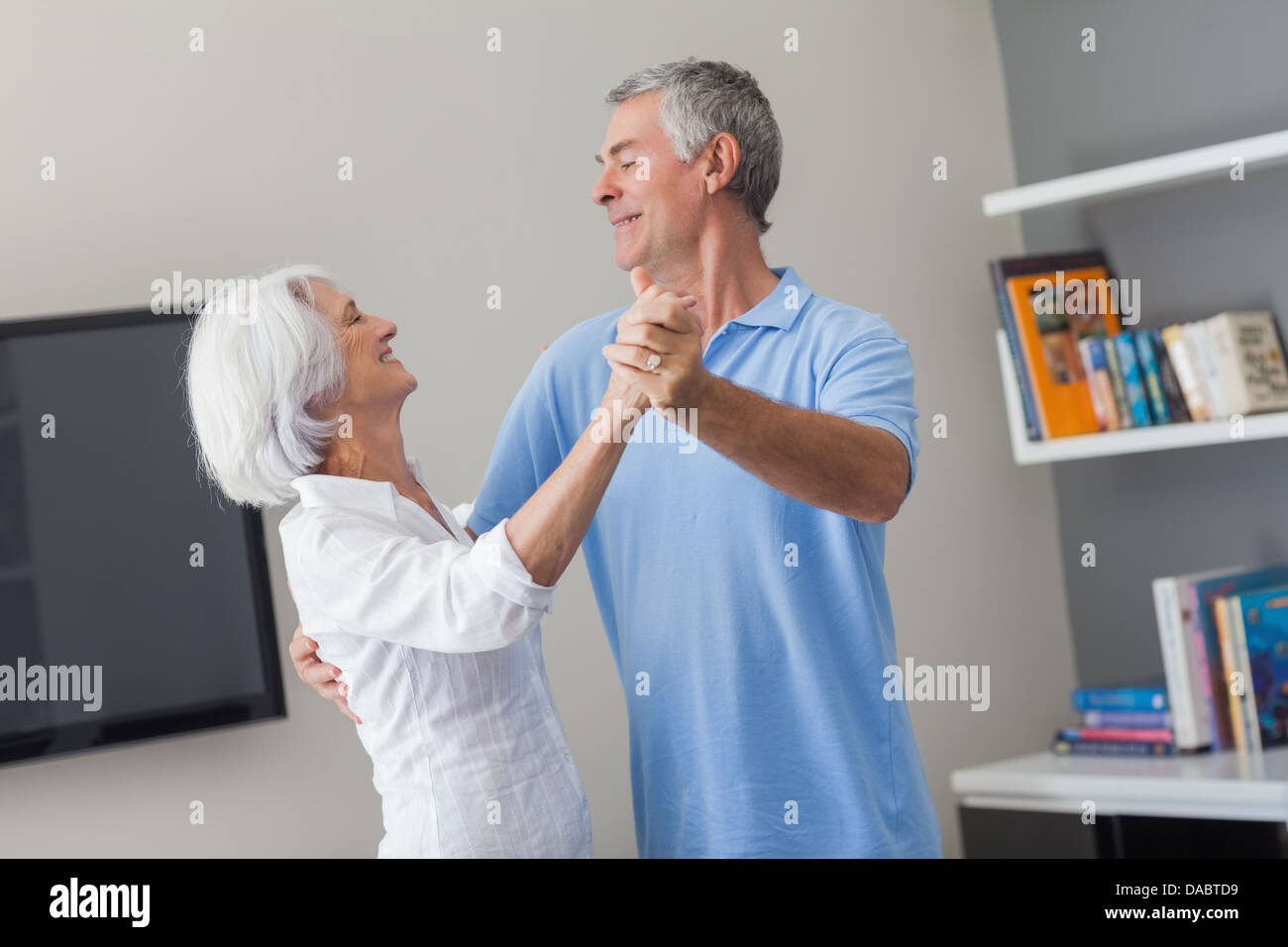 Elderly couple dancing in the living room Stock Photo