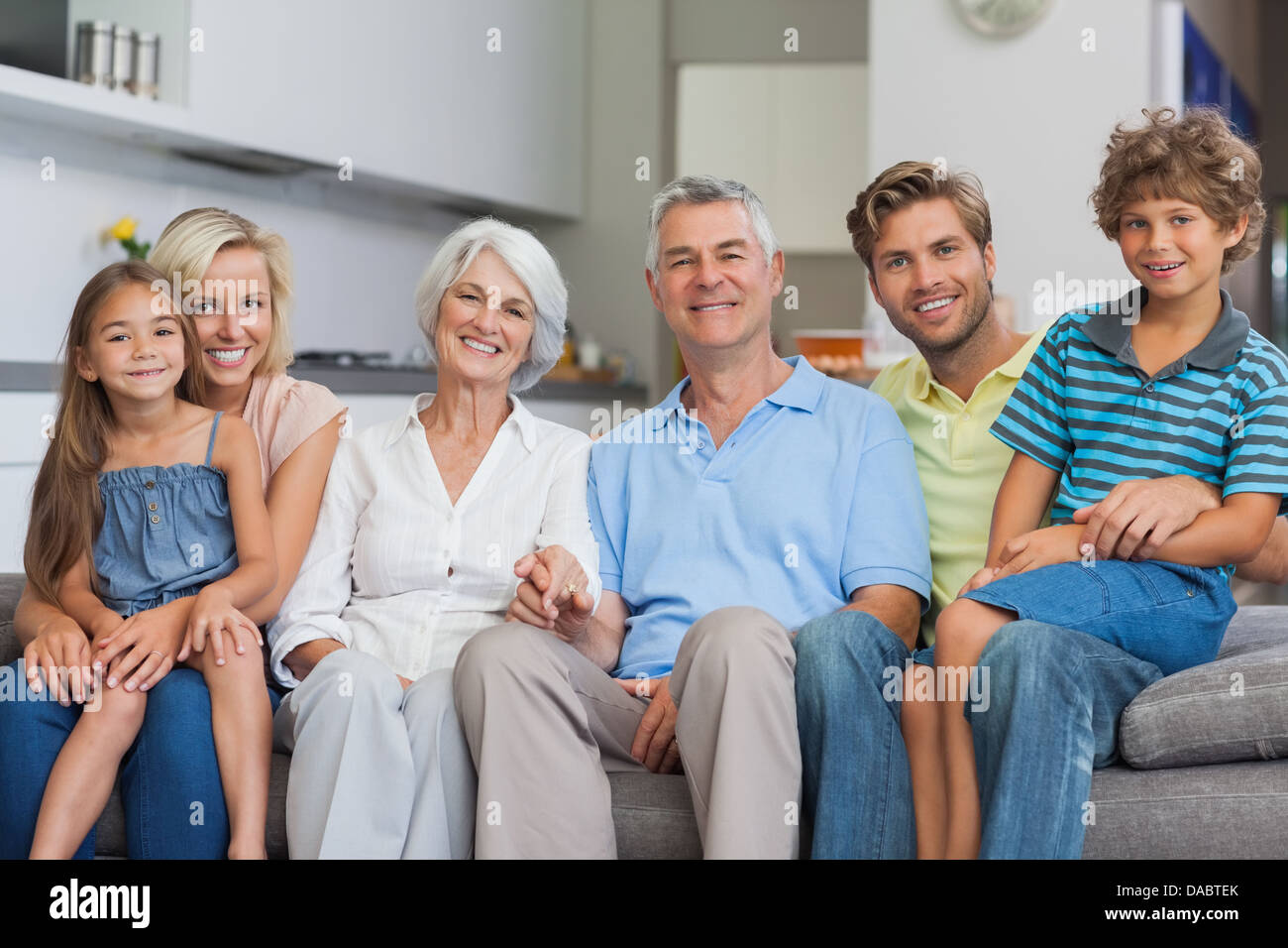 Extended family sitting on couch in living room Stock Photo - Alamy